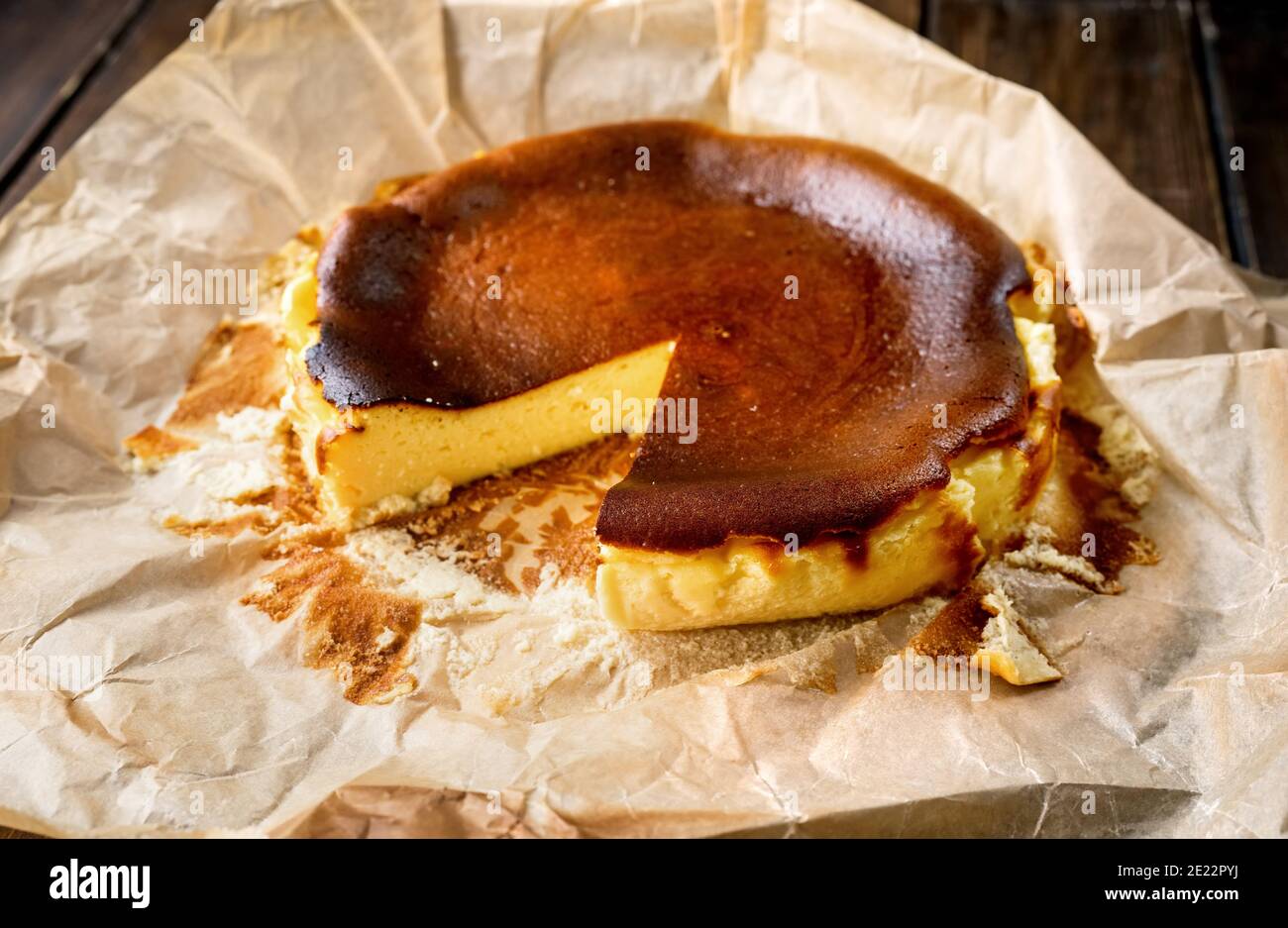 Délicieux cheesecake basque brûlé sur une table rustique sur du papier de cuisson Banque D'Images