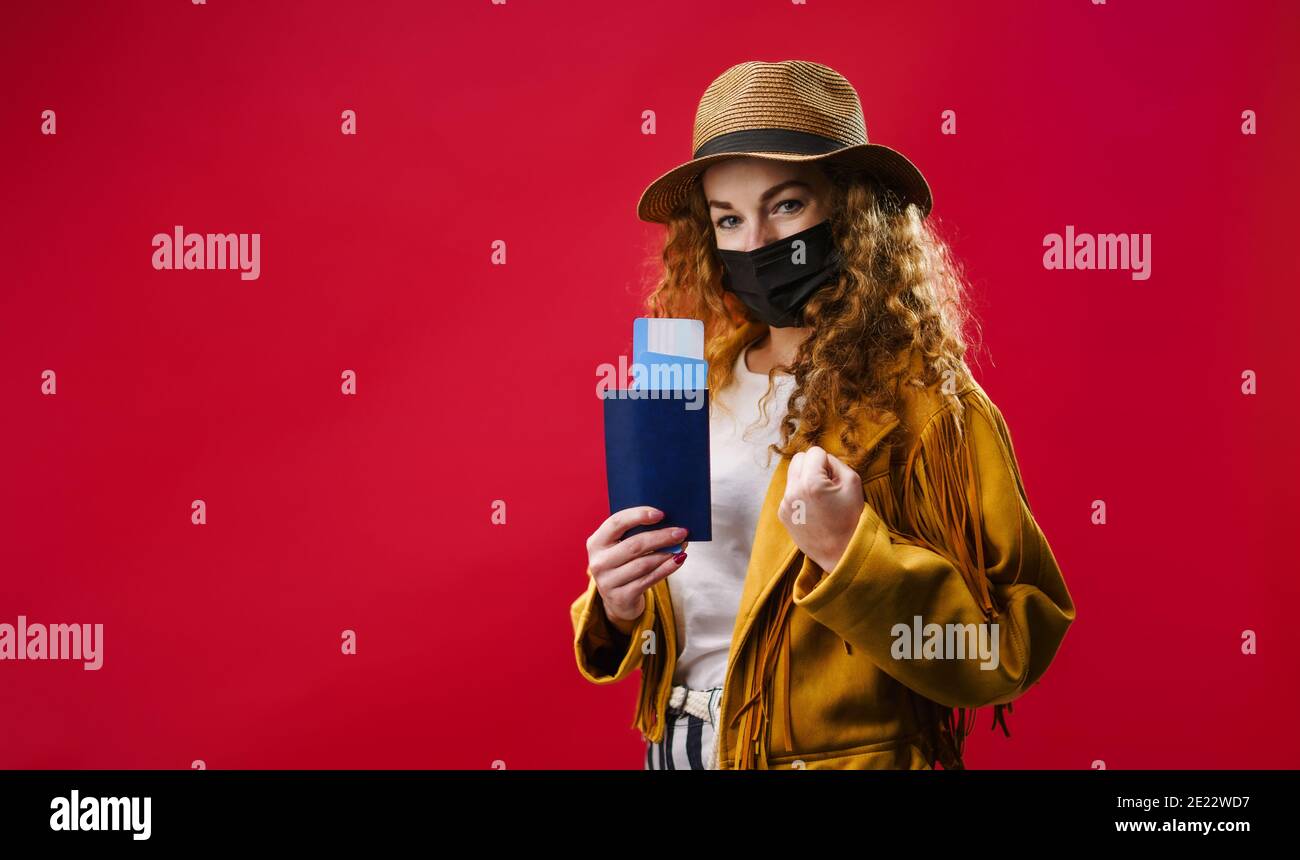 Jeune femme dans un studio tenant des billets d'avion, coronavirus et concept de voyage. Banque D'Images