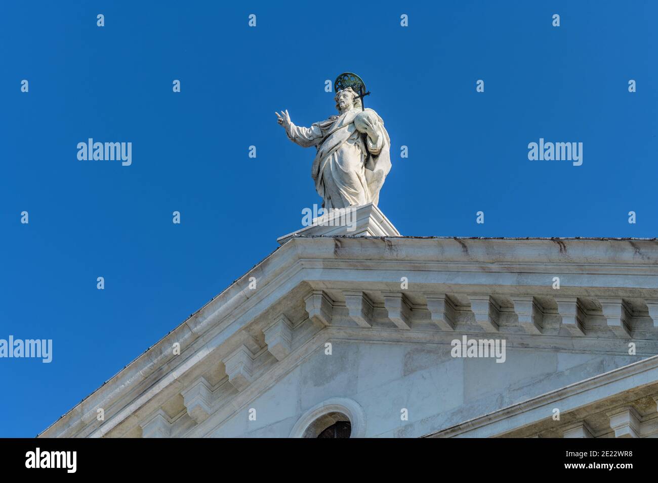 San Giorgio Maggiore - vue à angle bas d'une statue religieuse qui se dresse en haut de la façade de la basilique San Giorgio Maggiore du XVIe siècle. Venise, Italie. Banque D'Images