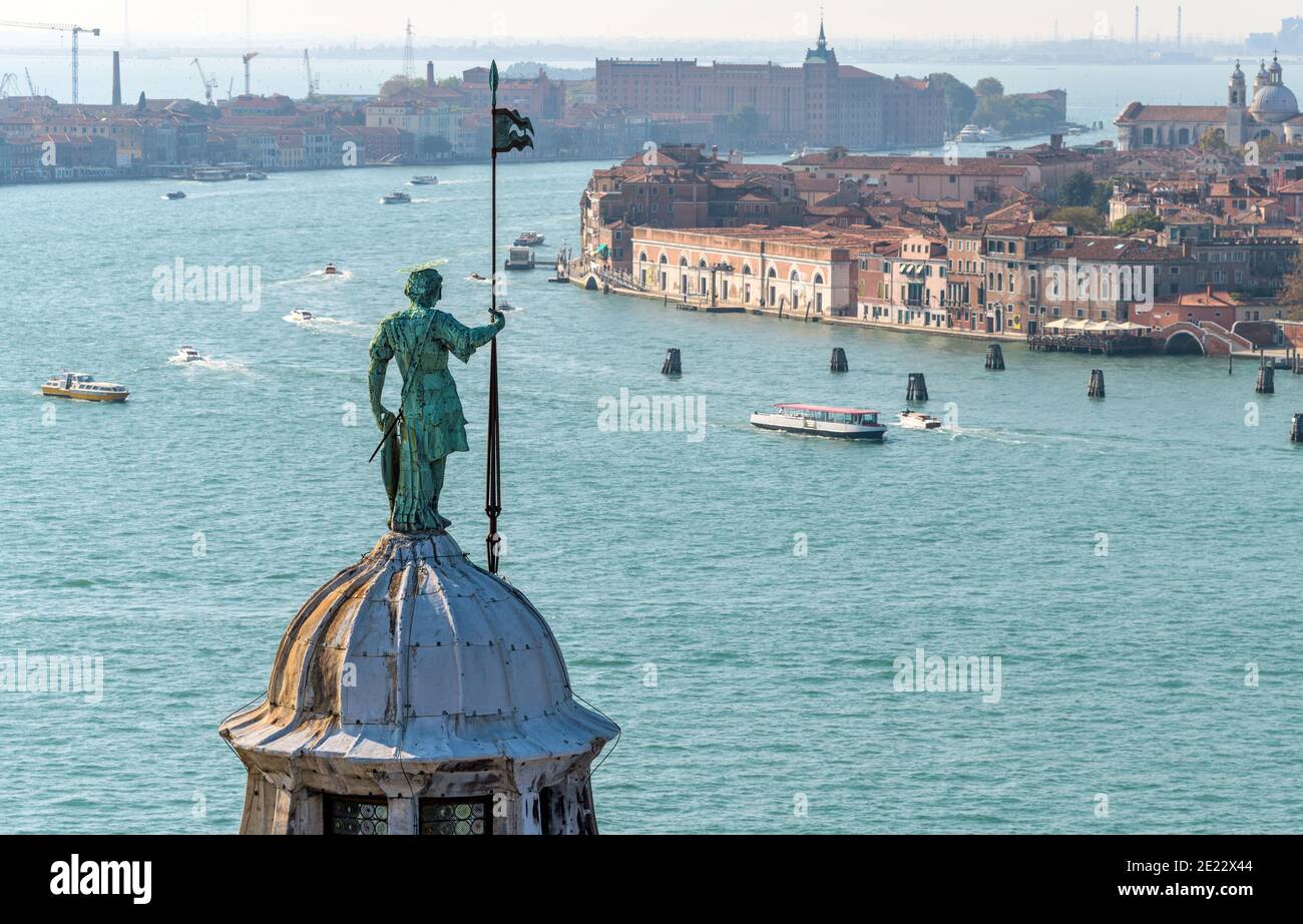 Ange gardien - UNE statue de bronze, debout au-dessus du dôme de la basilique de San Giorgio Maggiore, en regardant sur le très animé Canal Giudecca. Venise, Italie. Banque D'Images