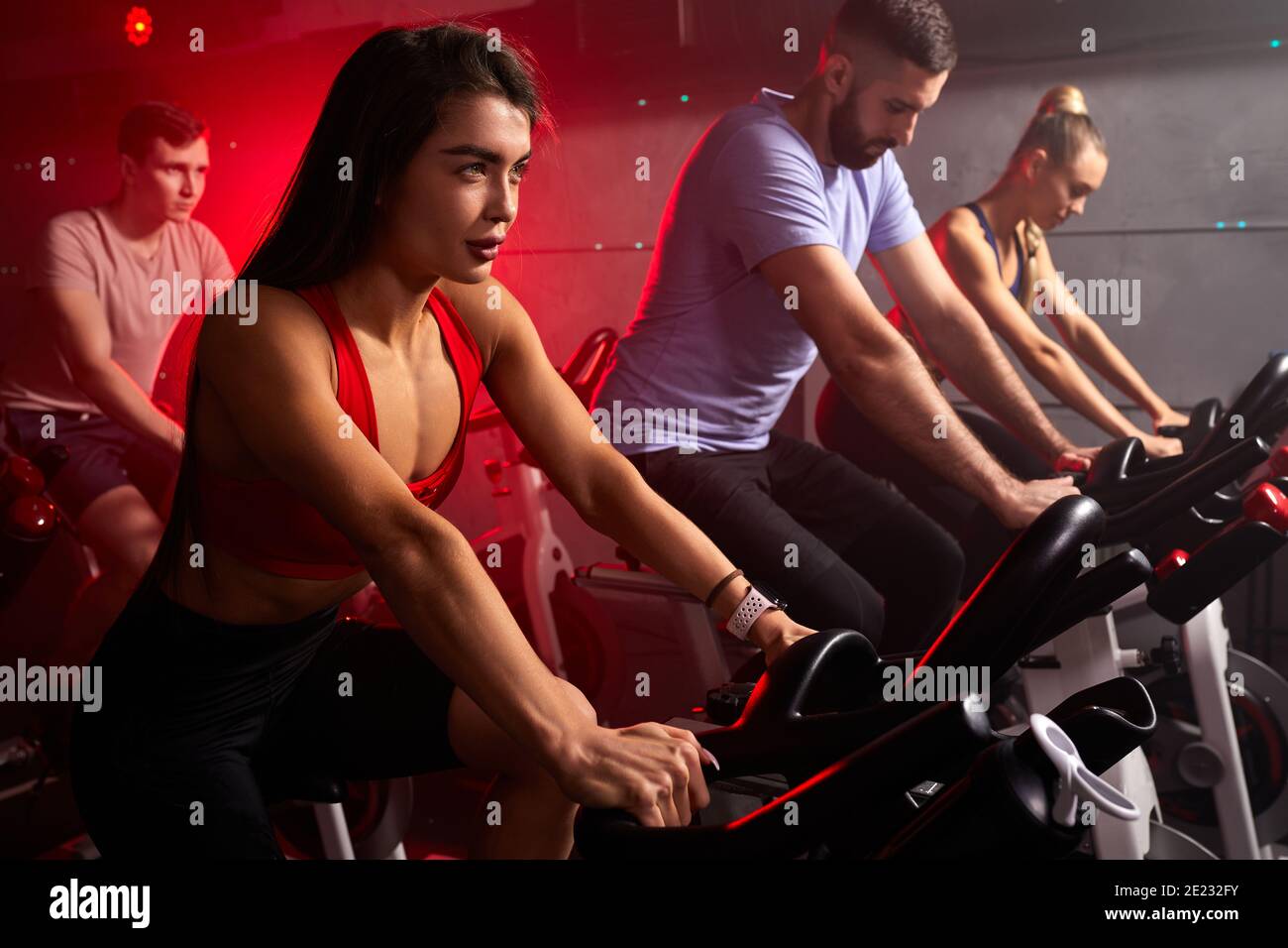 les gens se sont concentrés sur la perte de poids avec la machine aérobie pour le corps mince, assis sur le vélo, entraînement cardio intensif à la salle de fitness Banque D'Images