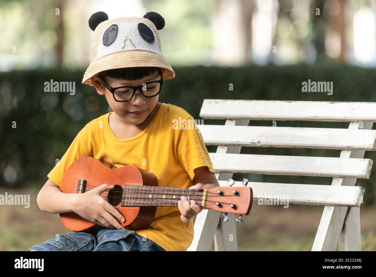 petit enfant asiatique mignon s'exerce à jouer du ukulélé. les enfants  apprennent la musique en cours. sur fond blanc de studio. 3679180 Photo de  stock chez Vecteezy