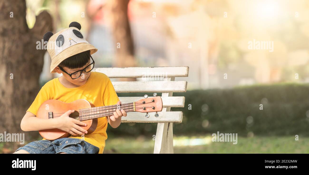 petit enfant asiatique mignon s'exerce à jouer du ukulélé. les enfants  apprennent la musique en cours. sur fond blanc de studio. 3679180 Photo de  stock chez Vecteezy