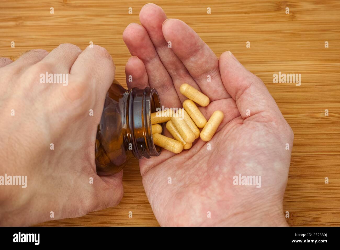 Personne prenant des pilules de complexe de vitamine B hors d'une bouteille. Gros plan. Banque D'Images