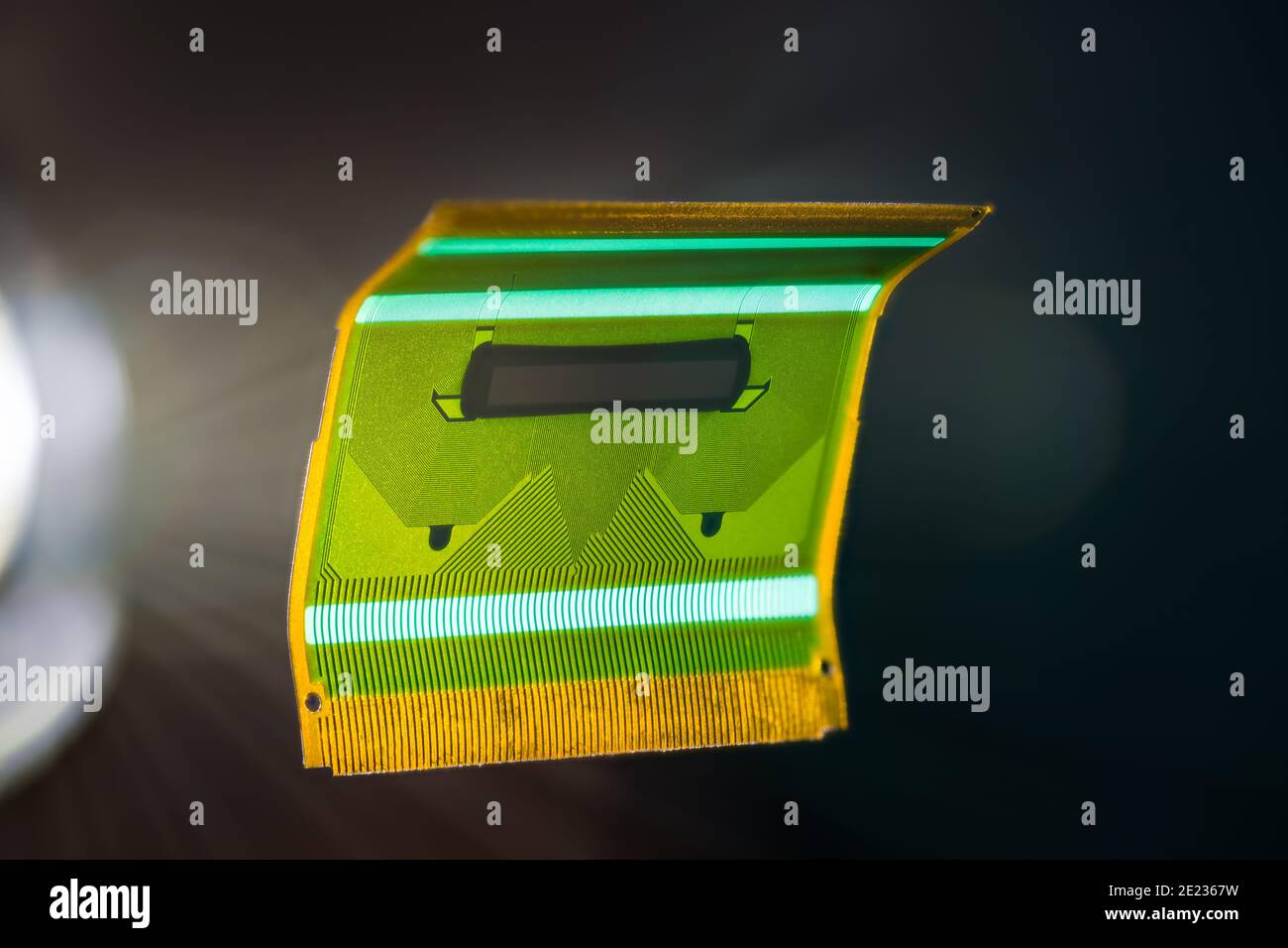 Circuit imprimé flexible vert flottant sur fond noir. Petit circuit imprimé flexible en plastique plié pour la transmission de signaux dans les écrans LCD des appareils électroniques. Banque D'Images