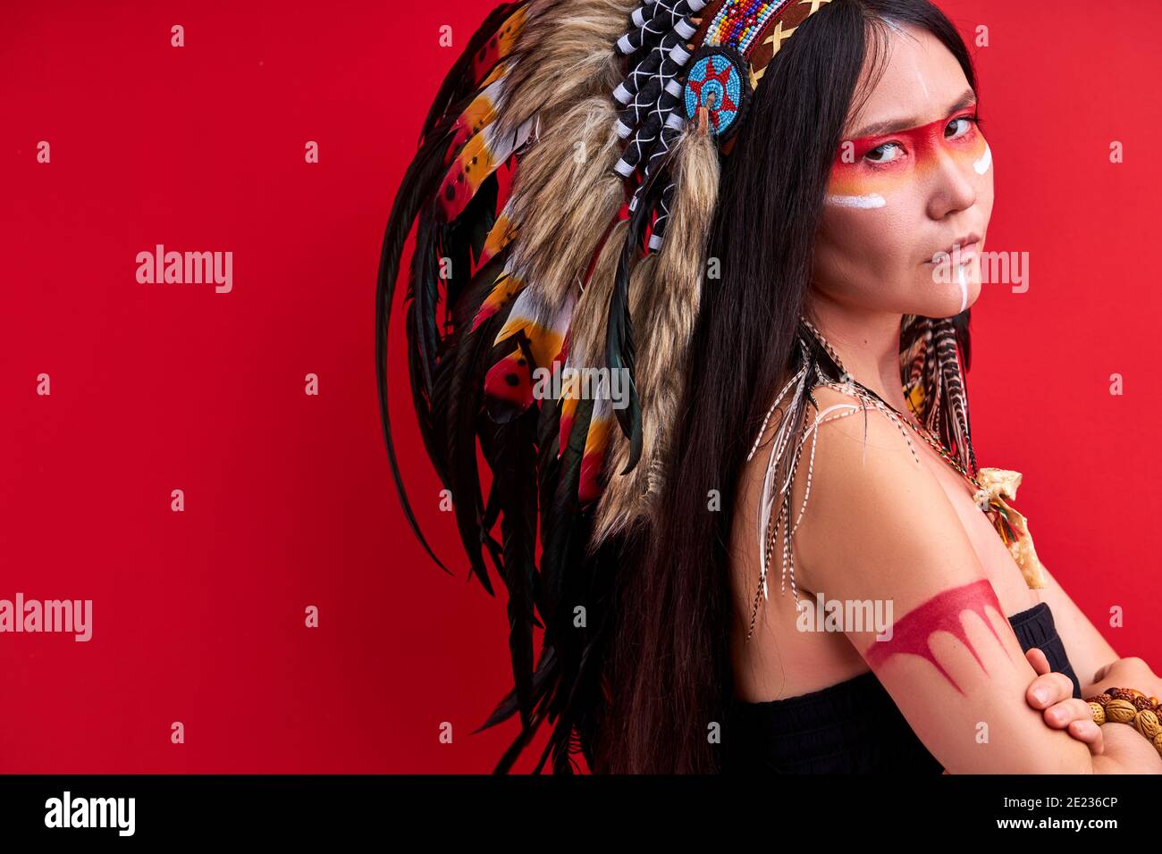 Portrait d'une femme en inde vêtue et maquillage coloré posant à la caméra, avec des plumes sur la tête. Tenue des peuples autochtones des Amériques, wom ethnique Banque D'Images