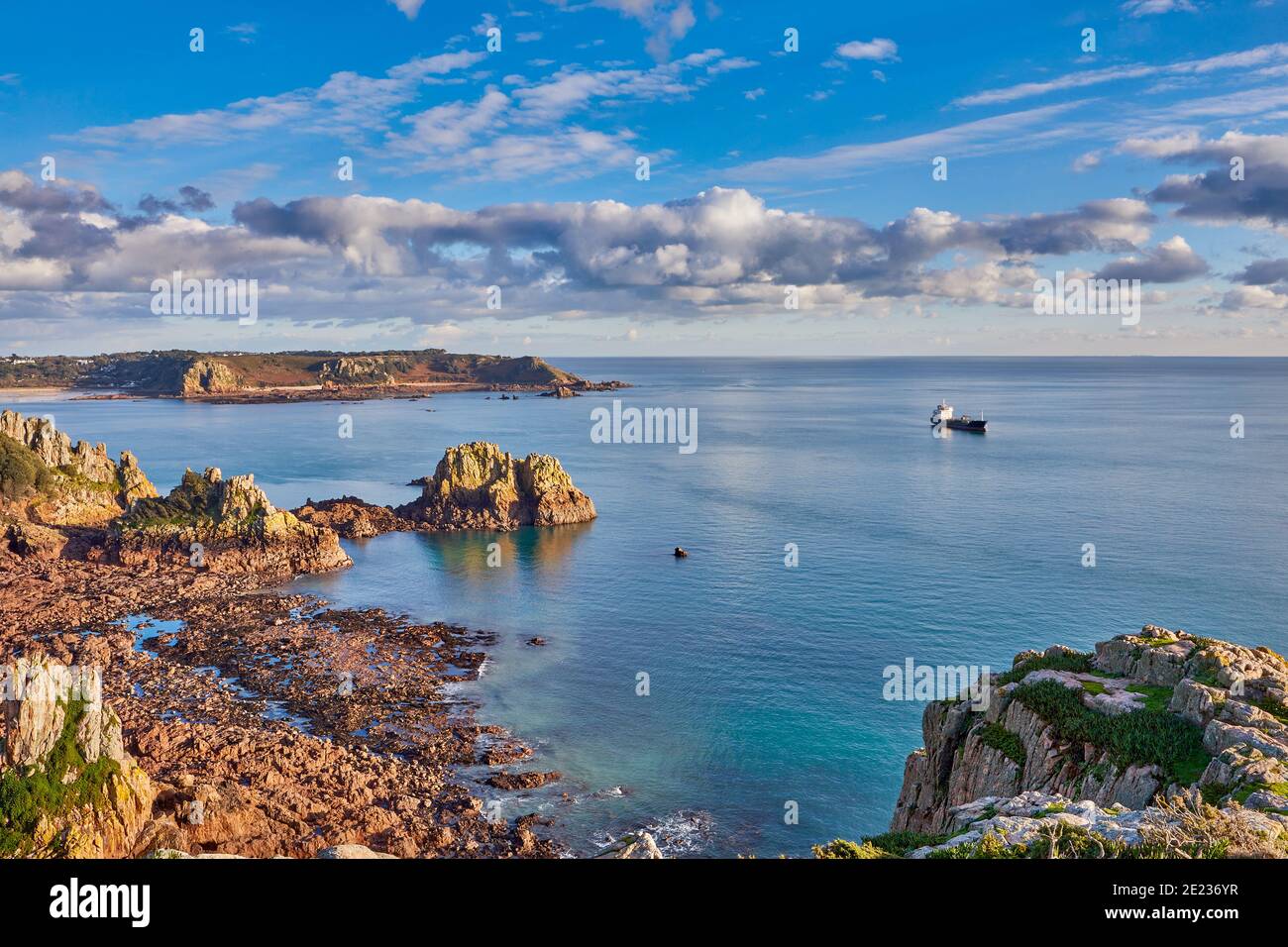 Image de la falaise entre la Corbière et la baie de St Brelade avec mer calme et ciel bleu avec nuages et un navire ancré dans la baie. Jersey, Cha Banque D'Images