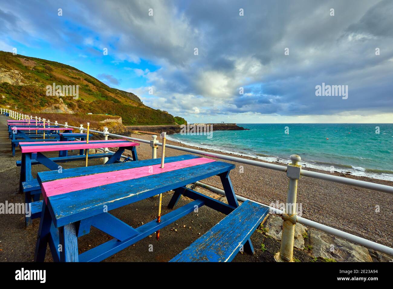 Image de Bouley Bay avec port en arrière-plan, plage et bancs de cafés en premier plan. Îles Jersey Channel Banque D'Images