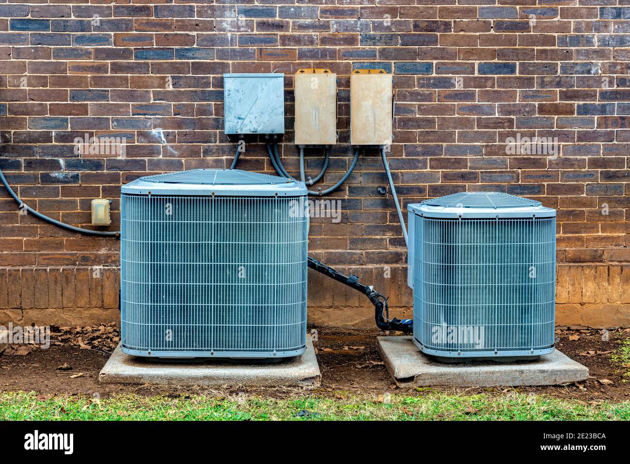 Gros plan horizontal des unités de climatisation à l'extérieur d'un petit immeuble de bureaux en briques. Banque D'Images