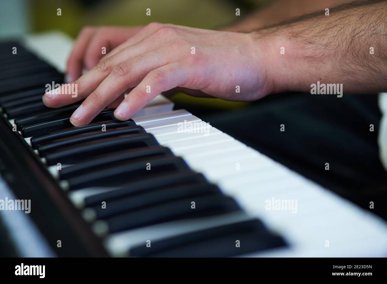 Gros plan de mains de musicien masculin jouant sur piano électronique clavier dans un studio Banque D'Images