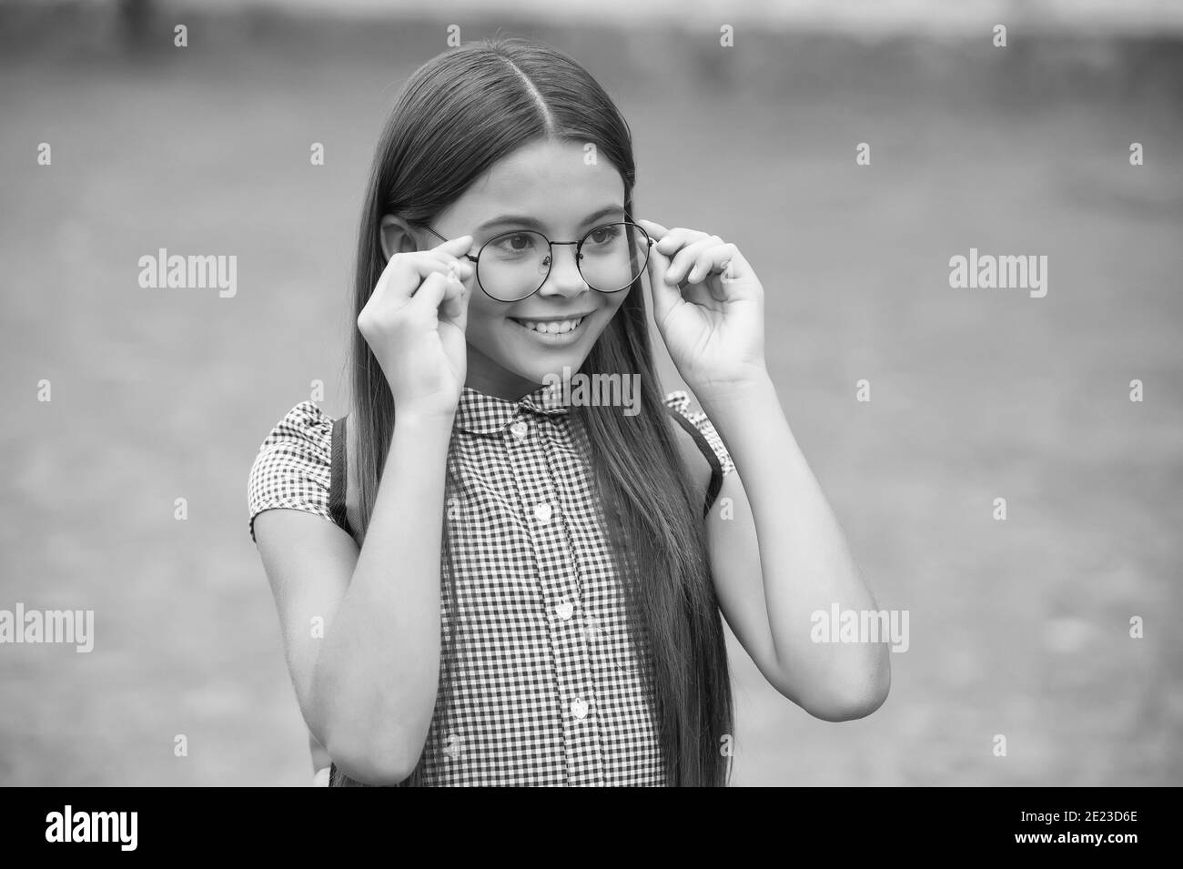 Bonne petite fille avec de longs cheveux fixer des lunettes sur le nez avec  le look mignon été extérieur, lunettes Photo Stock - Alamy