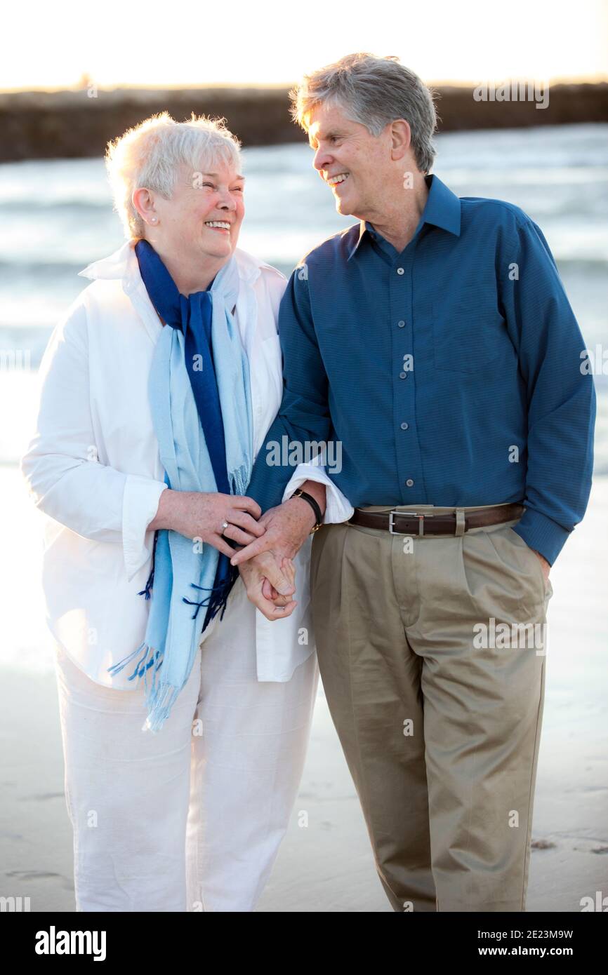 Portrait d'un couple marié plus âgé tenant les mains et en riant Plage Banque D'Images