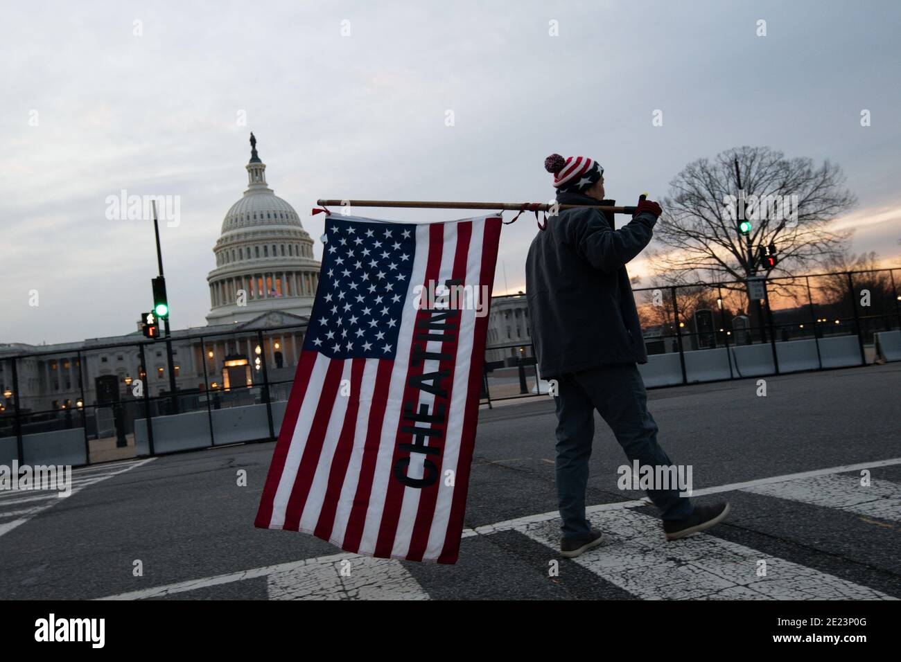 Washington, États-Unis. 11 janvier 2021. Penny, de Falls Church, va, passe devant le bâtiment du Capitole des États-Unis, tenant un drapeau américain avec le mot « tricherie » imprimé dessus, à Washington, DC, le 11 janvier 2021, dans le contexte de la pandémie du coronavirus. Des milliers de membres de la Garde nationale des États-Unis arrivent à Washington pour des préparatifs de sécurité avant l'inauguration de Biden-Harris avec des groupes extrémistes de droite qui prévoient des manifestations armées dans tout le pays et à Washington dans les jours à venir. (Graeme Sloan/Sipa USA) Credit: SIPA USA/Alay Live News Banque D'Images