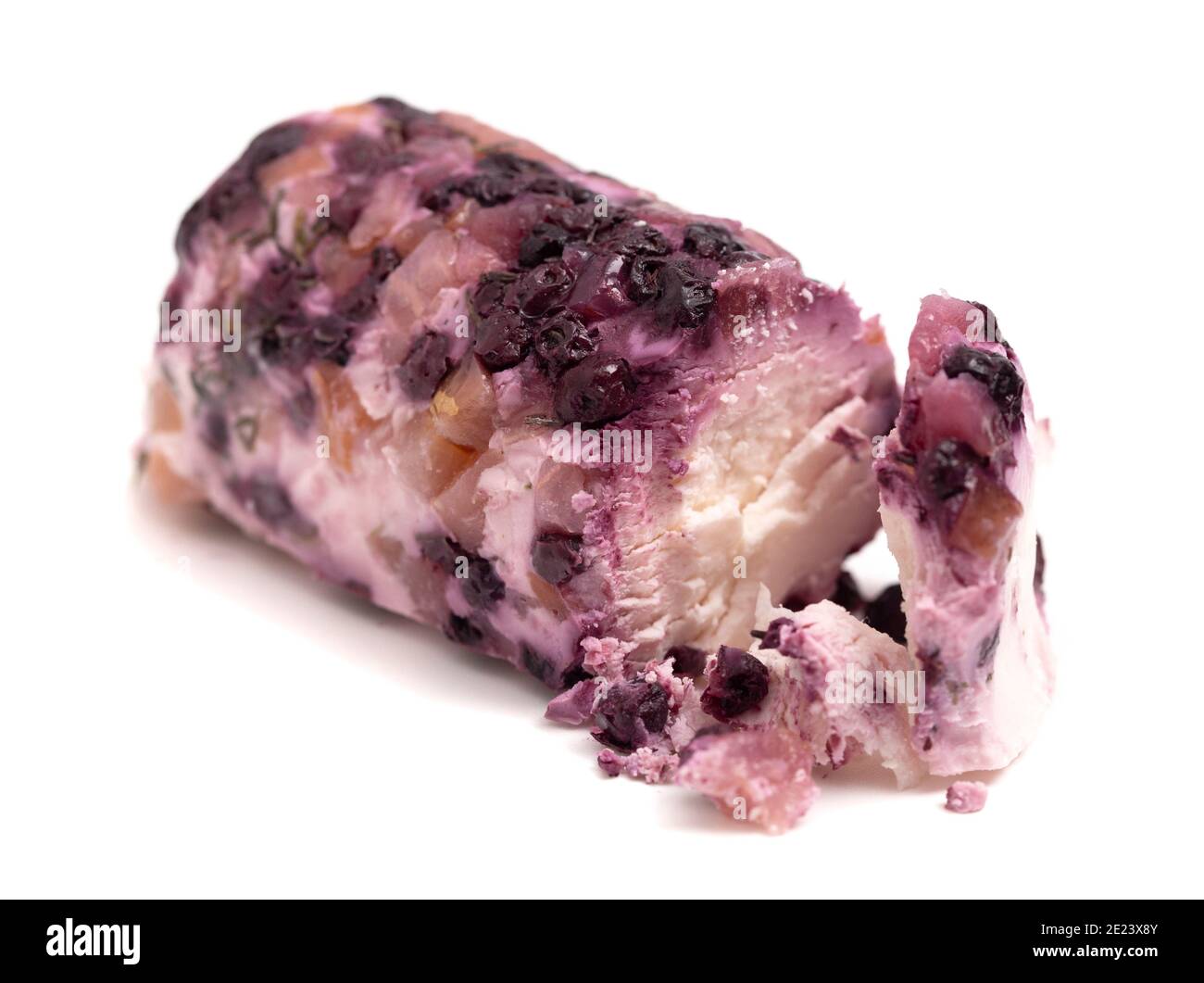 Une Log de fromage de chèvre recouverte de baies violettes isolées Sur fond blanc Banque D'Images