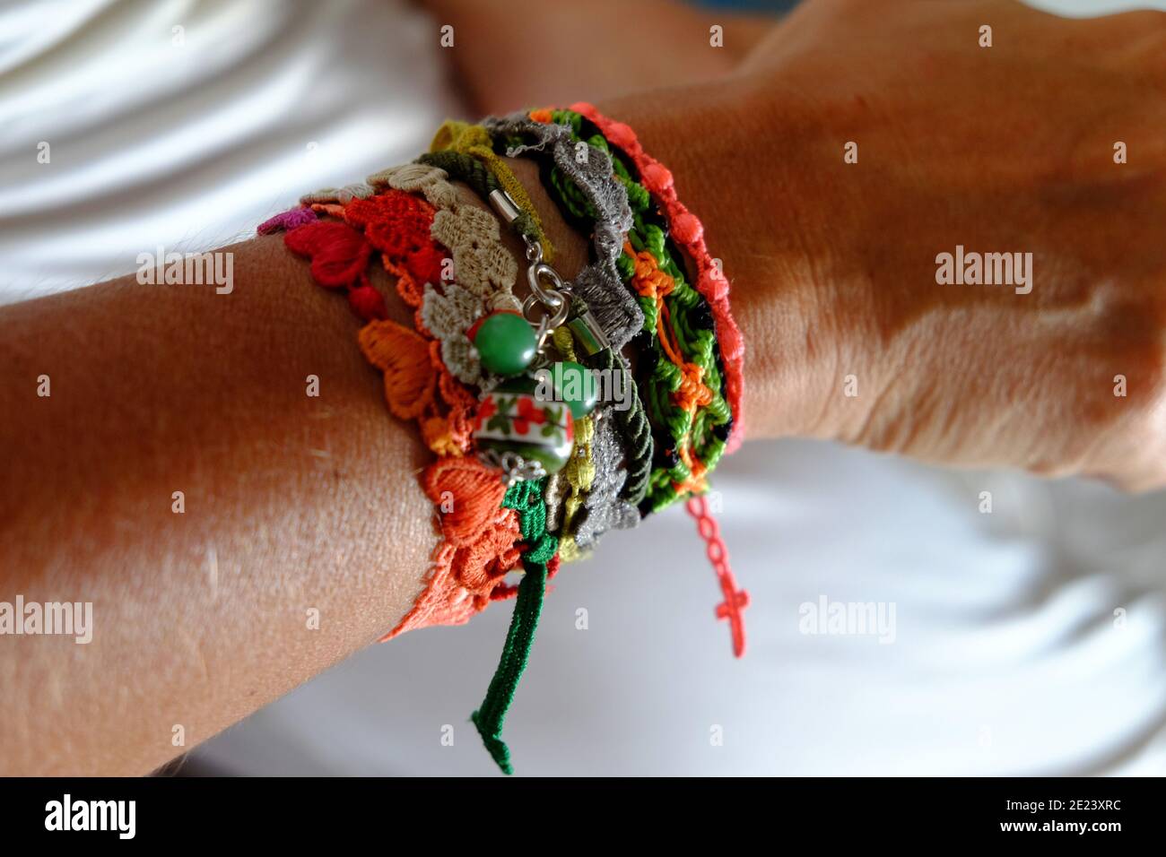 Gros plan de divers bracelets colorés sur un bras Banque D'Images