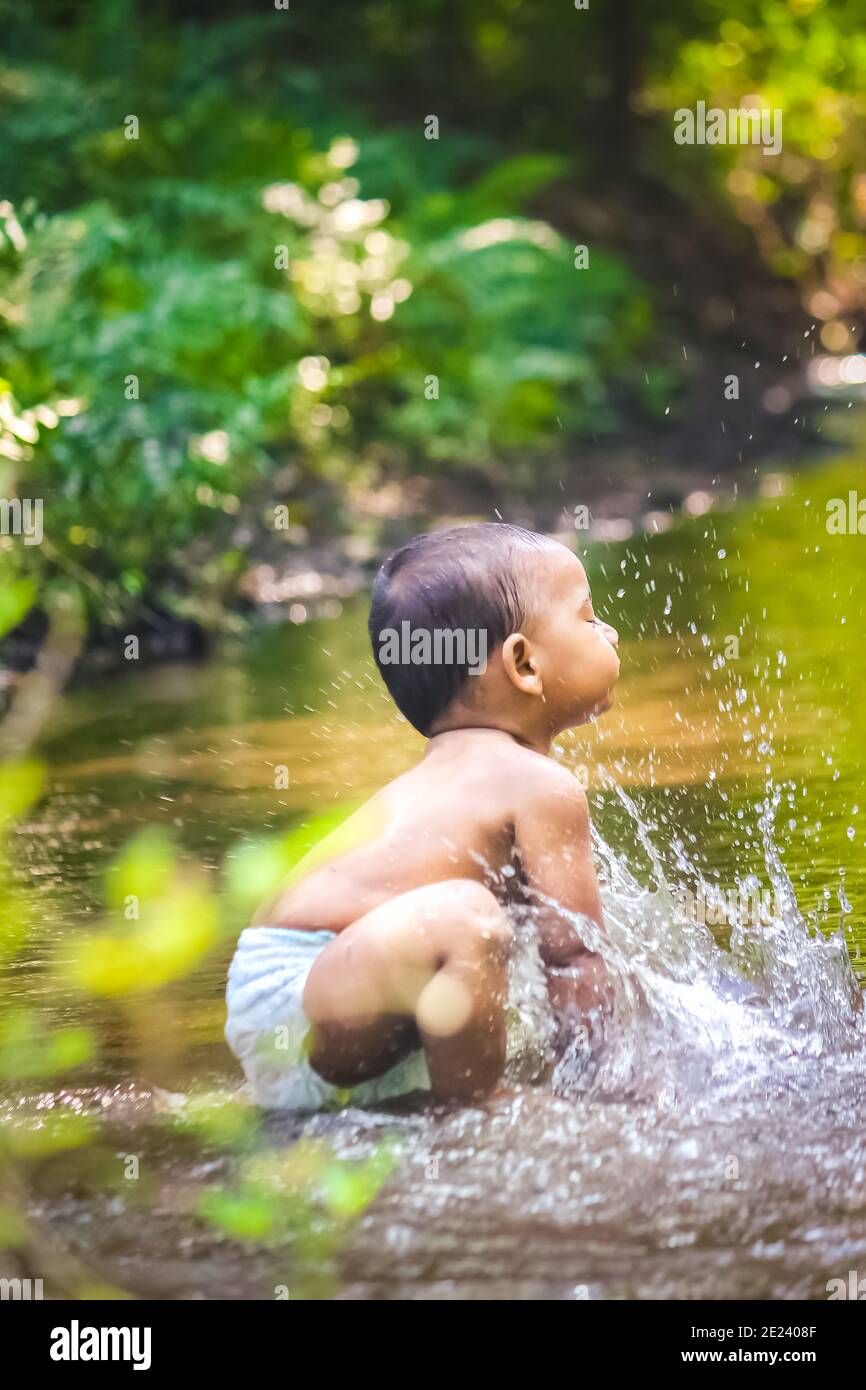 Petit garçon mignon jouant dans l'eau de la rivière. Portrait d'un enfant de garçon ayant du plaisir et de la joie sur une rivière de la forêt. Petit garçon drôle jouant dans l'eau. Bébé garçon S Banque D'Images