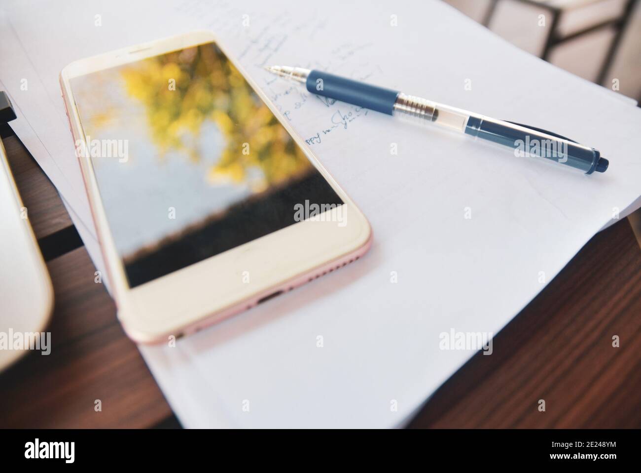 Smartphone sujet flou avec stylo sur document de travail papier Banque D'Images