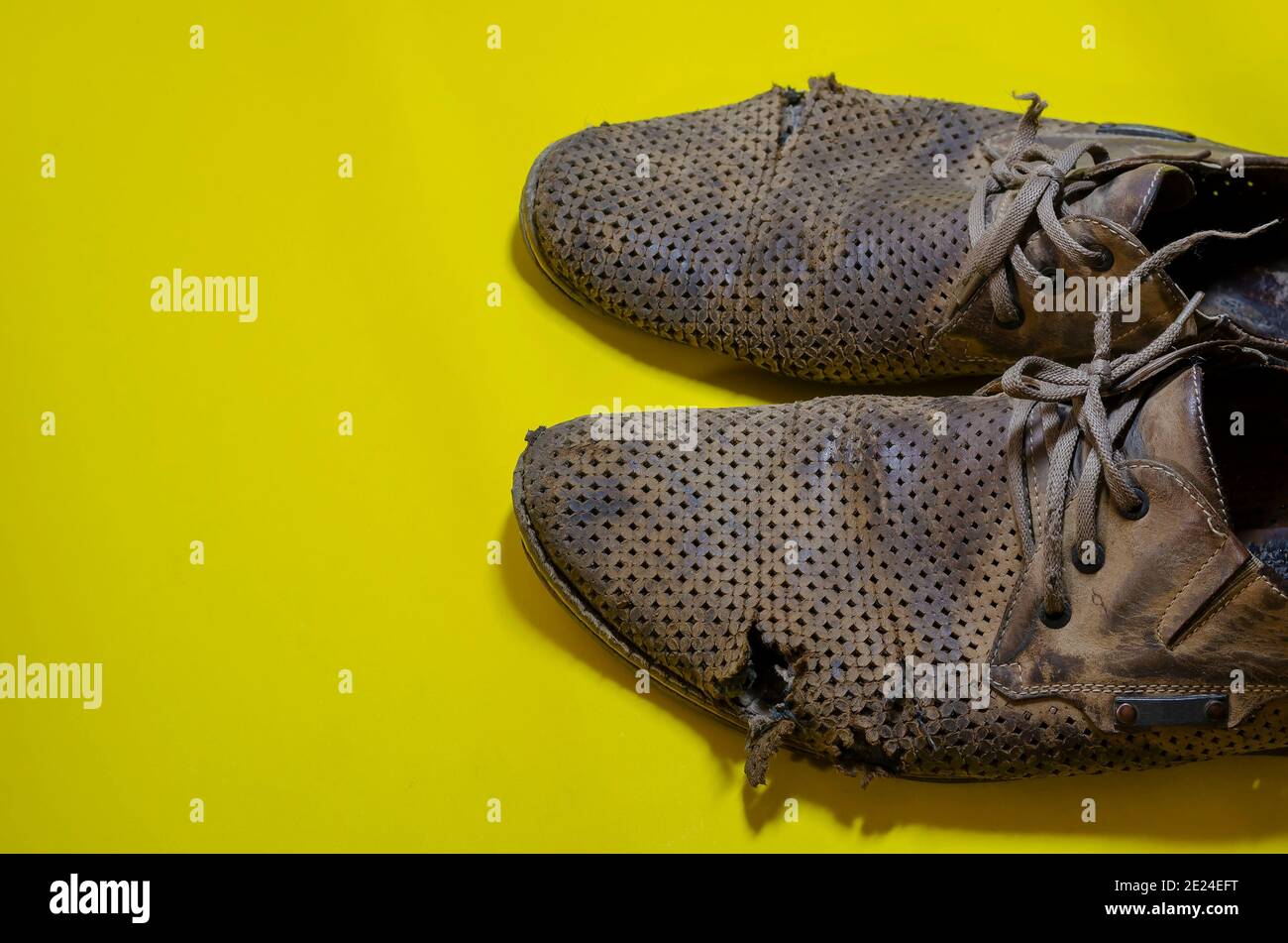 Vieilles chaussures d'été jaunes déchirées sur fond jaune. Une paire de  chaussures en cuir très portées pour homme Photo Stock - Alamy