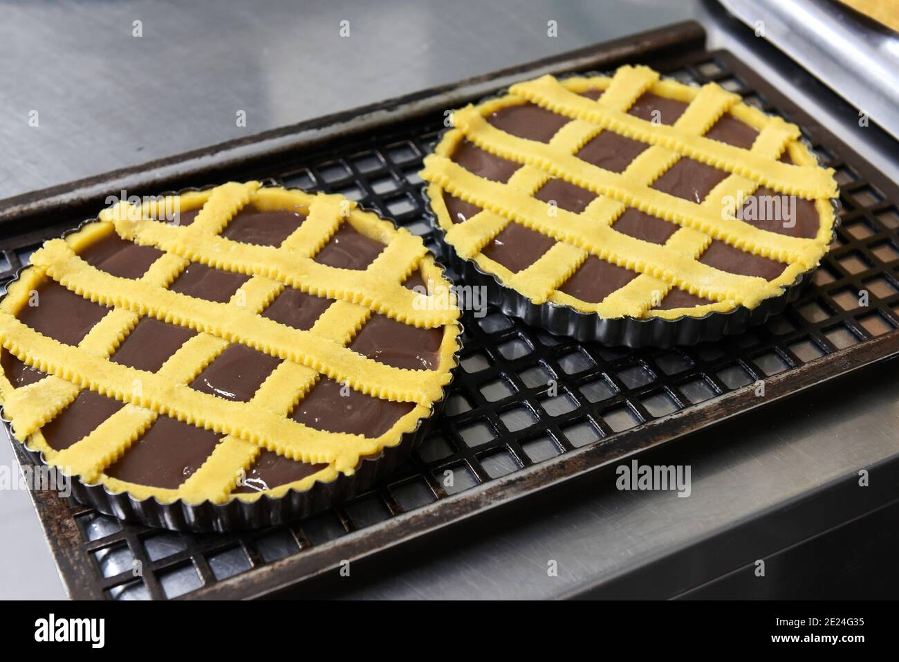 Deux gâteaux ou tartes au chocolat fraîchement cuits sur des plaques de cuisson se tenir sur une grille métallique pour refroidir à la fermeture un grand angle sur un comptoir de cuisine Banque D'Images
