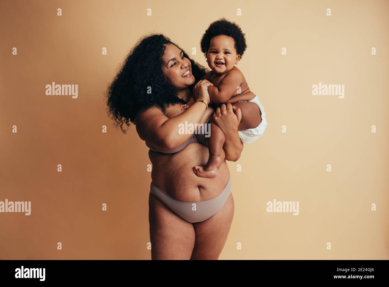 Femme africaine souriante de taille plus avec bébé. Mère et enfant en bonne santé. Banque D'Images