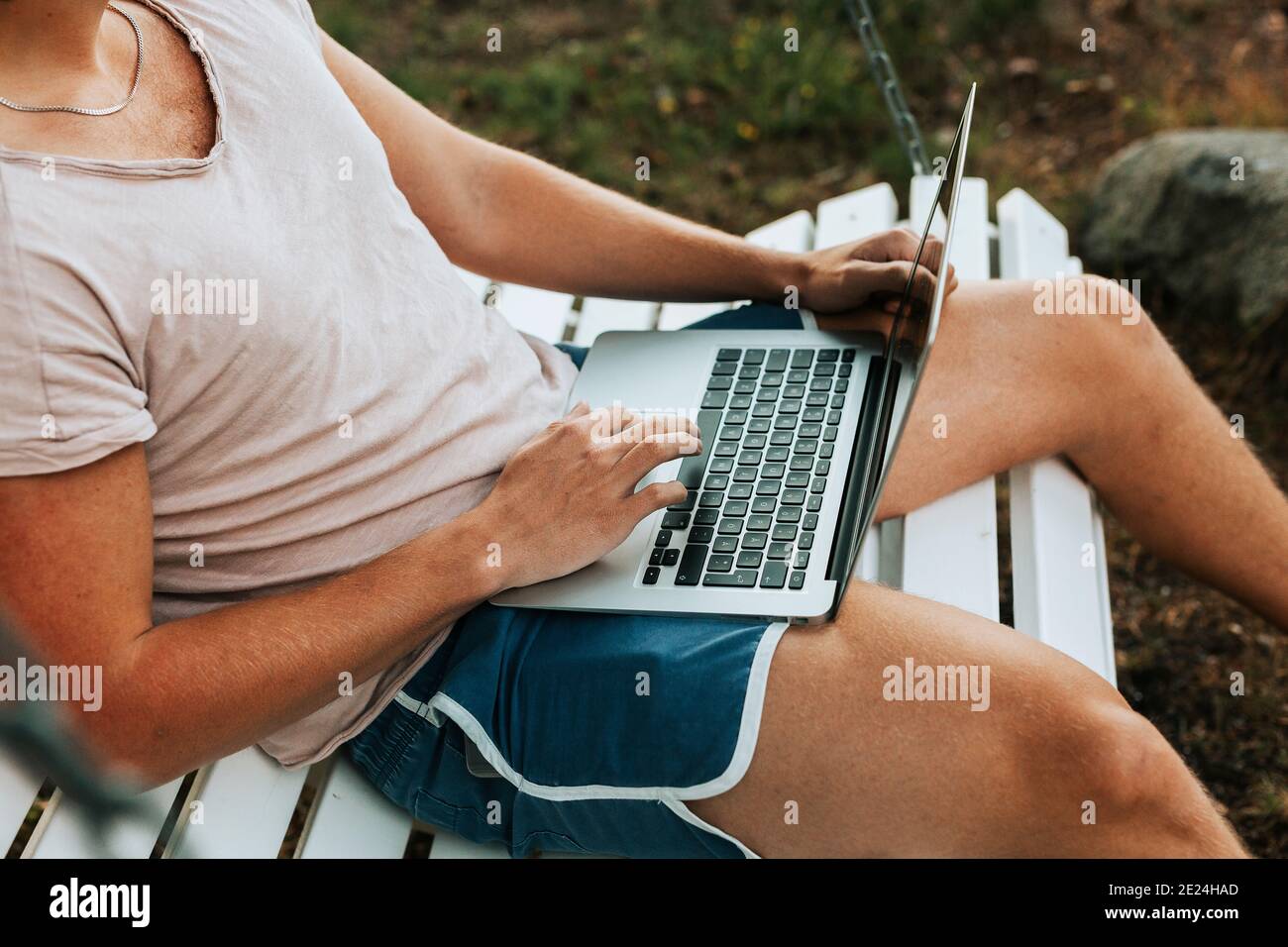 Homme utilisant un ordinateur portable sur la balançoire de la paillasse Banque D'Images