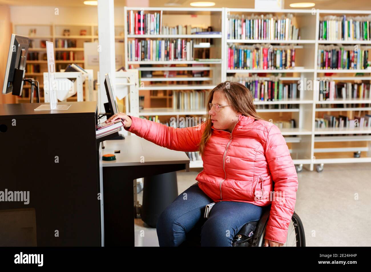 Femme en fauteuil roulant dans la bibliothèque Banque D'Images