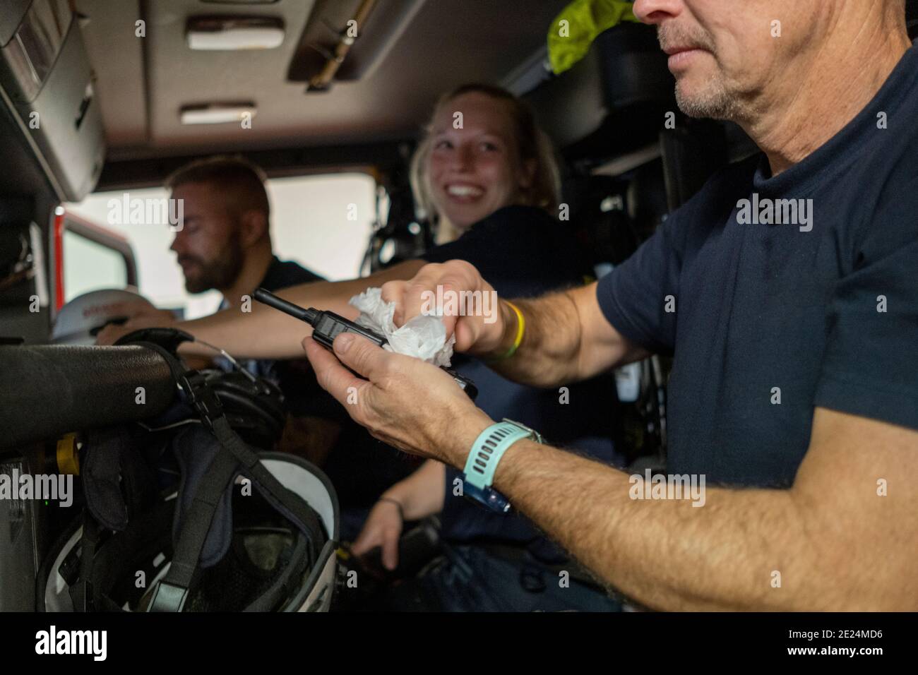 Un pompier dans un walkie portatif de nettoyage de moteur d'incendie Banque D'Images