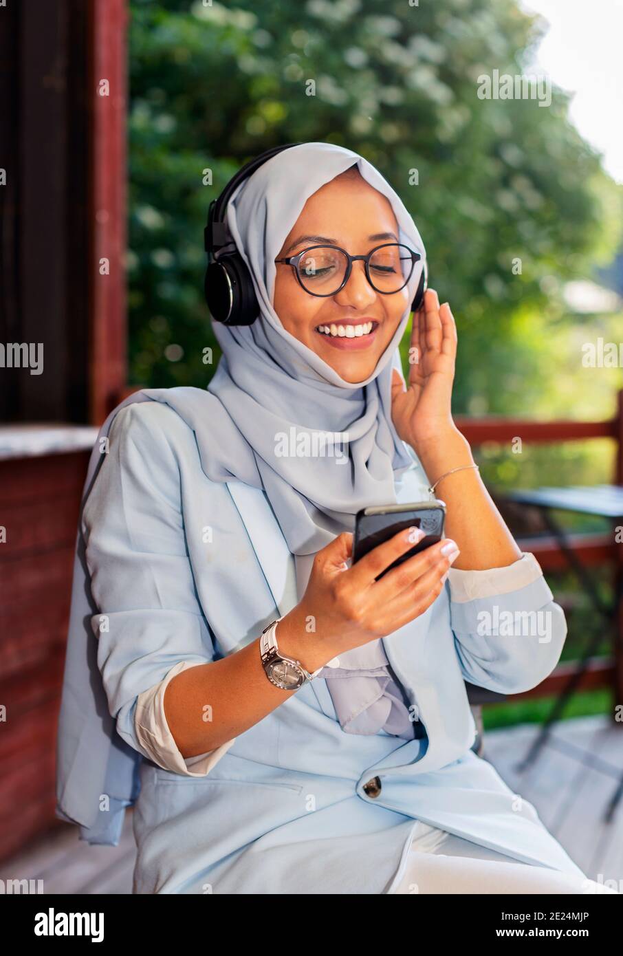 Femme souriante écoutant de la musique via un casque Banque D'Images