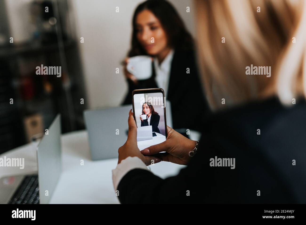 Femme prenant la photo d'une collègue de travail au bureau Banque D'Images