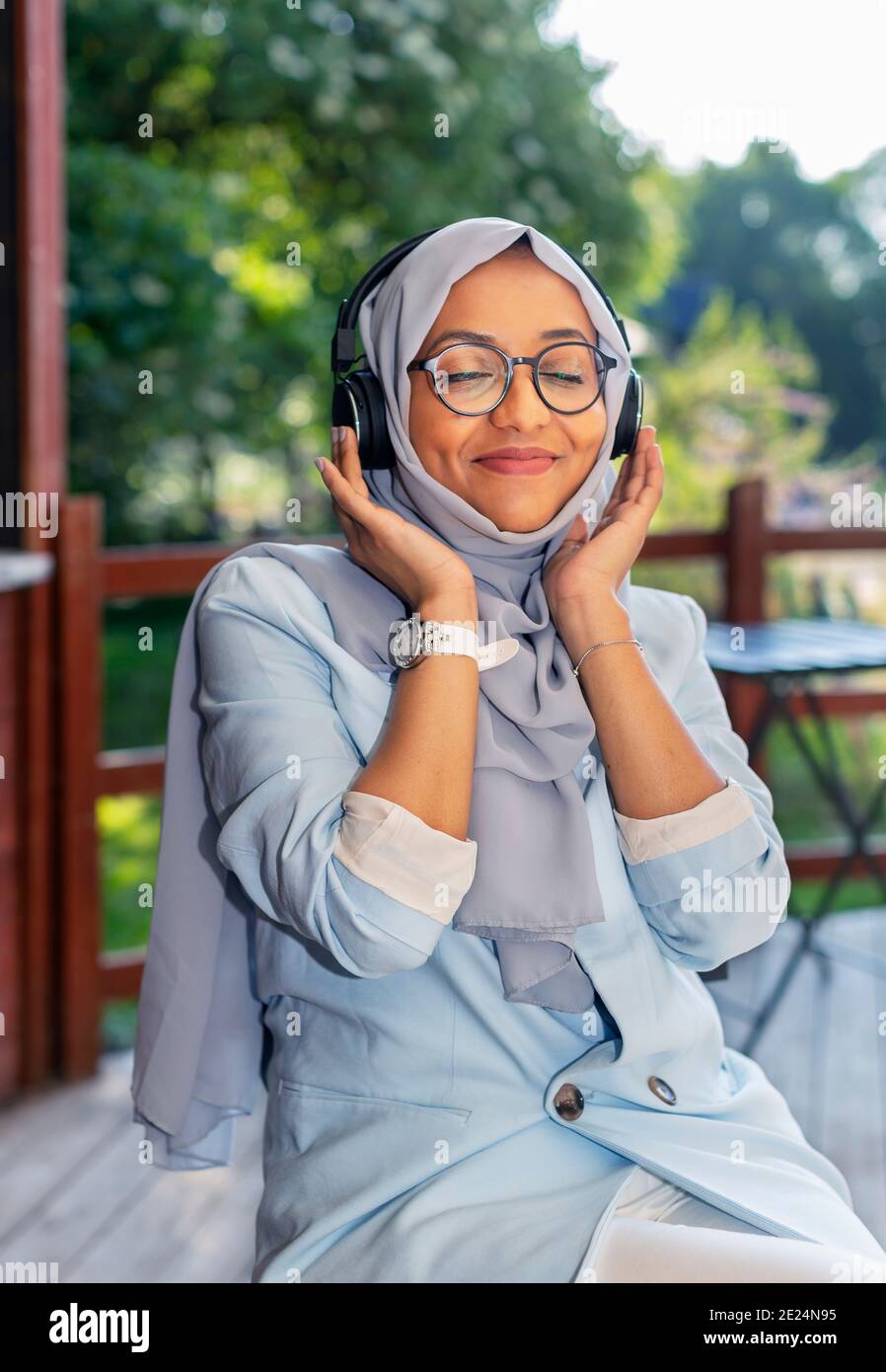 Femme souriante écoutant de la musique via un casque Banque D'Images
