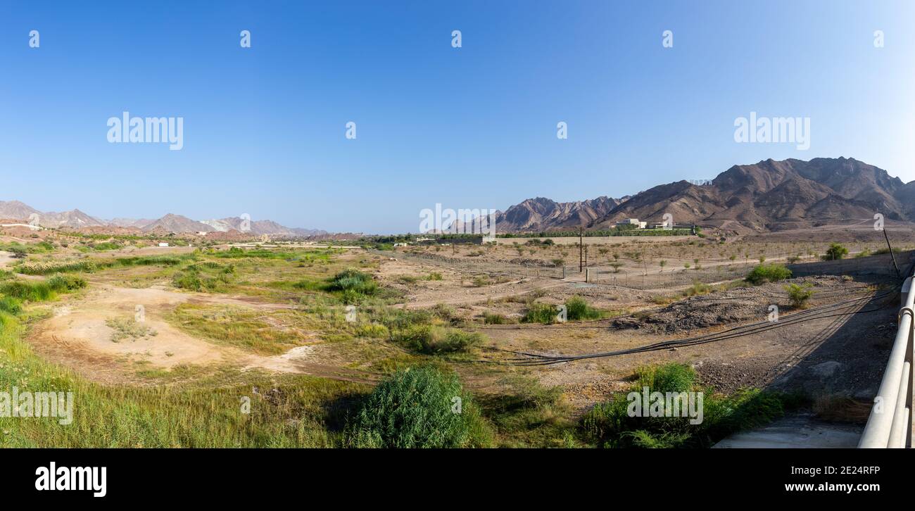 Sheikh Maktoum Bin Rashid Al Maktoum Dam Riverbed in Hatta, avec une végétation verte et des montagnes Hajar en arrière-plan, Émirats arabes Unis, panorama Banque D'Images