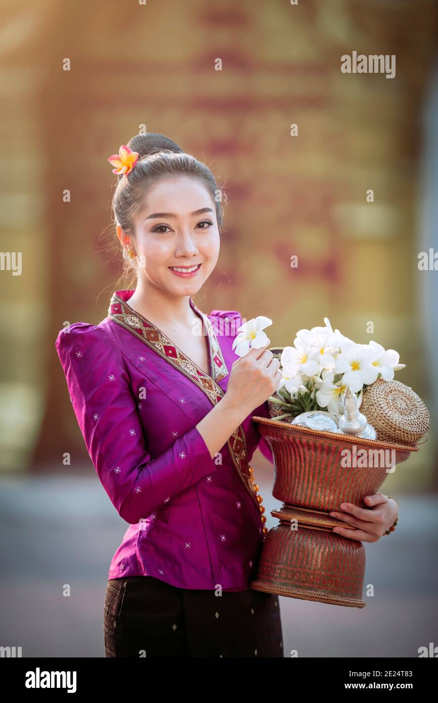 Portrait d'une belle femme tenant un bol avec des fleurs fraîches, Thaïlande Banque D'Images