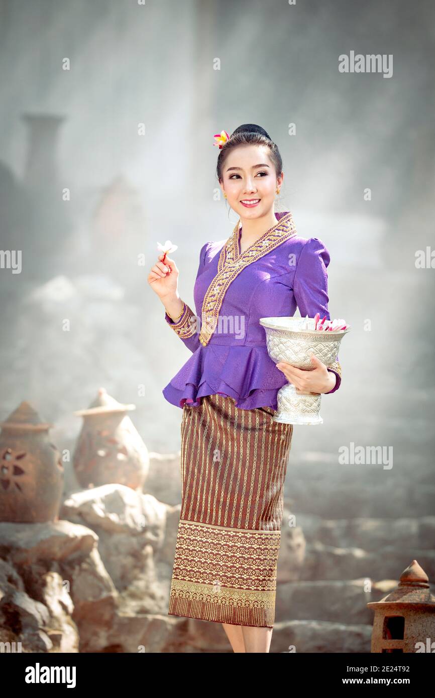 Portrait d'une belle femme tenant un bol avec des fleurs fraîches, Thaïlande Banque D'Images