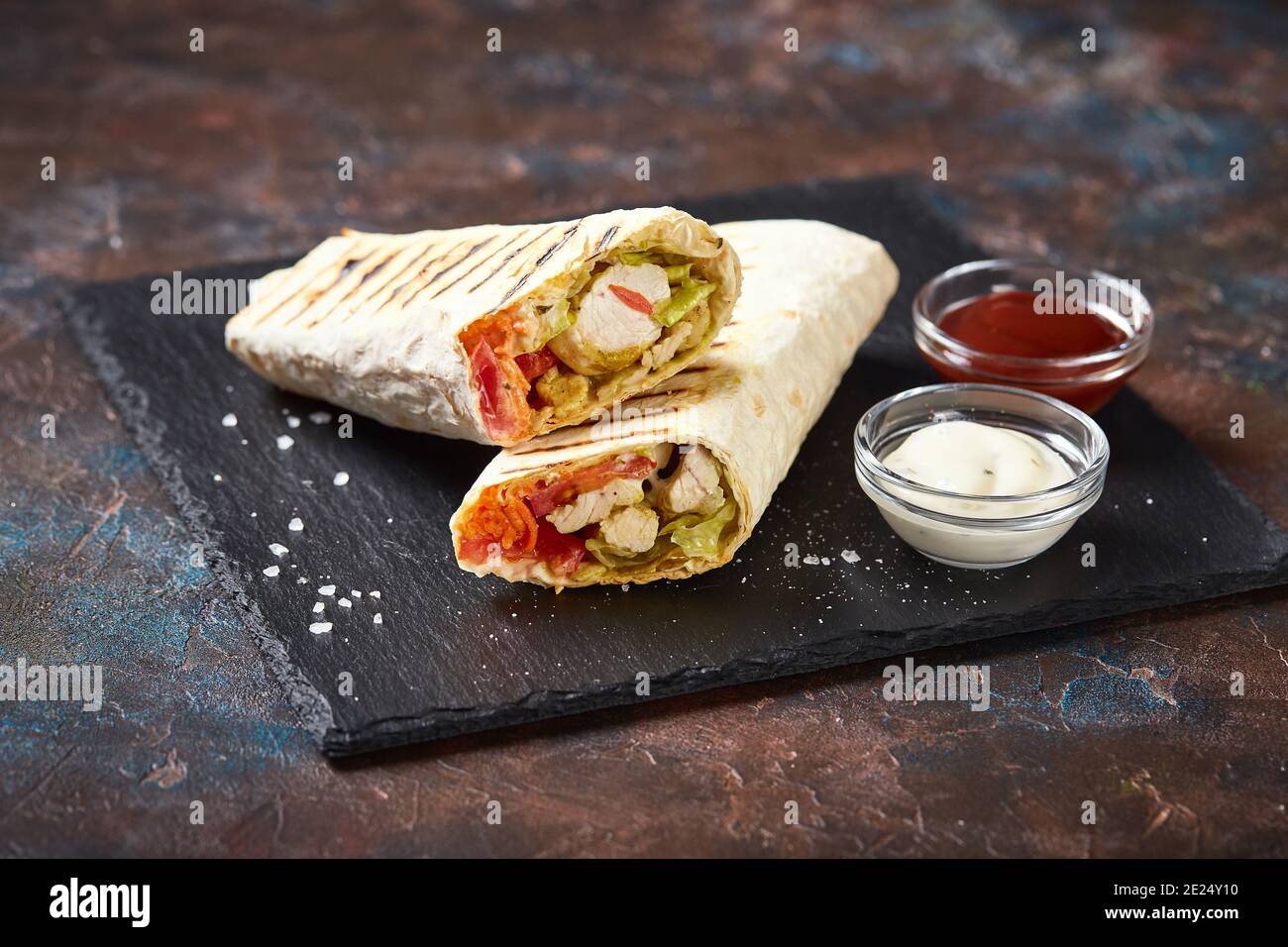 Shawarma traditionnel de l'est avec poulet et légumes, donner Kebab avec sauces sur ardoise. Restauration rapide. Cuisine de l'est. Banque D'Images