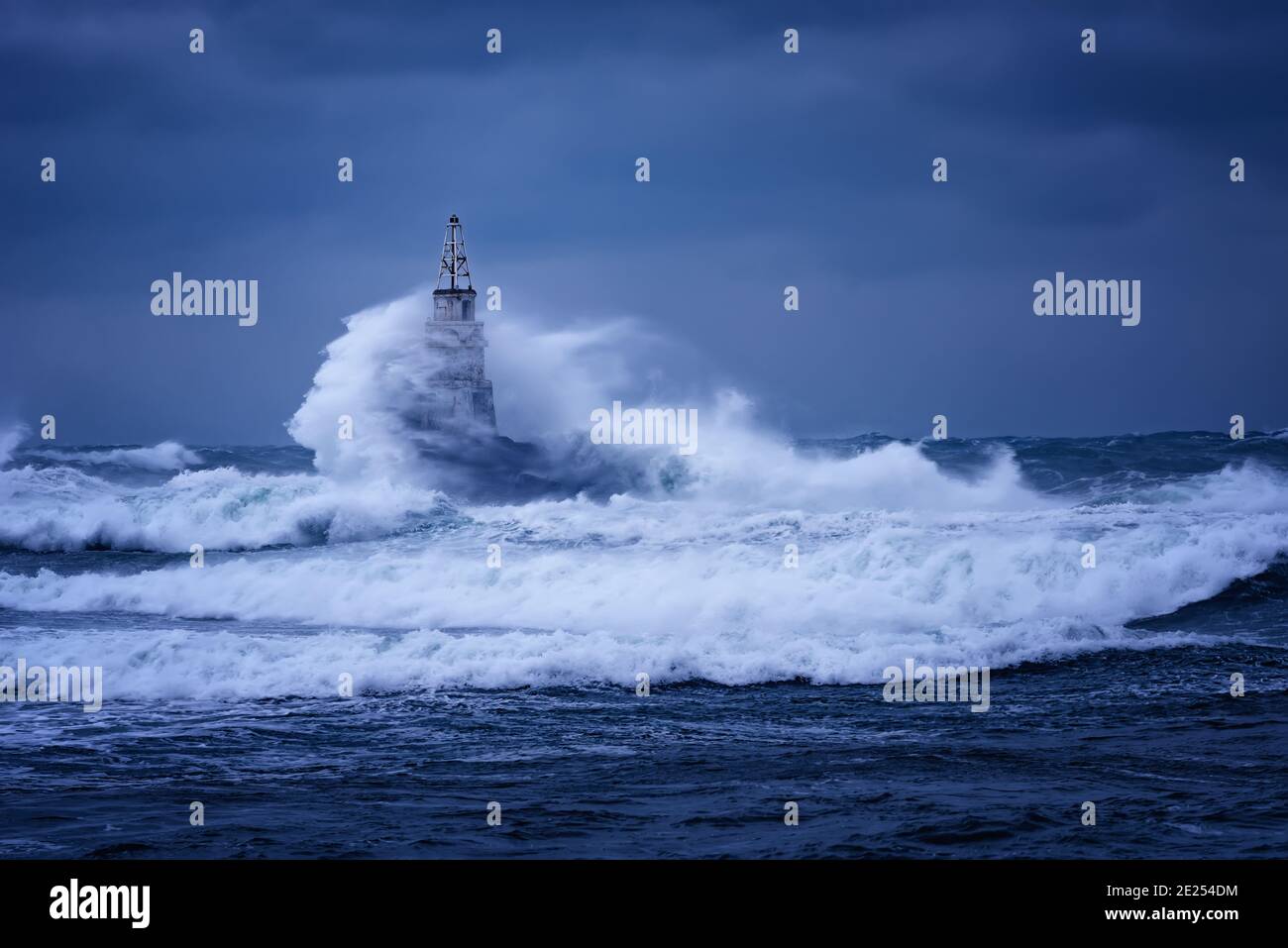 Grande vague contre le vieux phare dans le port d'Ahtopol, la mer Noire, la Bulgarie sur une journée de tempête de moody. Danger, scène dramatique. Banque D'Images