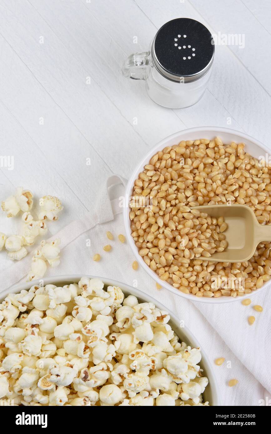 Préparation de popcorn à plat. Bols de pop-corn et de grains sur une table rustique blanche avec espace de copie. Banque D'Images