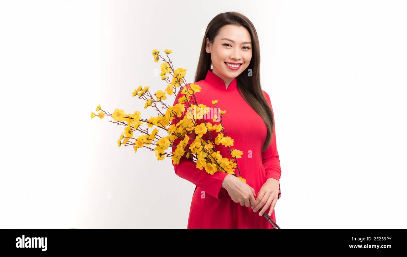 Femme asiatique avec robe traditionnelle vietnamienne ao dai tenant fleur de fleur pour les décorations. Nouveau concept d'année lunaire Banque D'Images