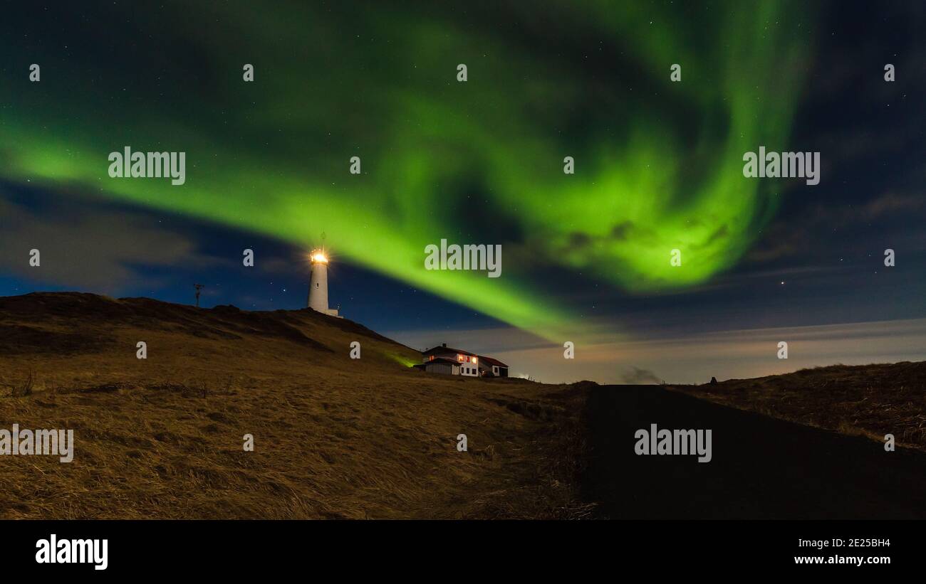 Les beaux aurores boréales ou aurores borealis en Islande avec phare près de Keflavik nommé phare de Reykjanes. Banque D'Images