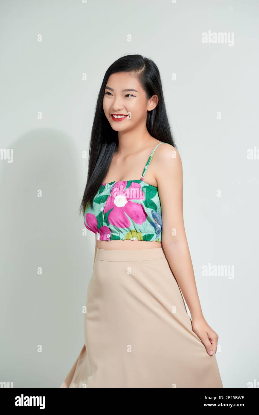 Très tendance jeune beau modèle posé sur fond blanc studio portant un petit top à motif floral. Banque D'Images