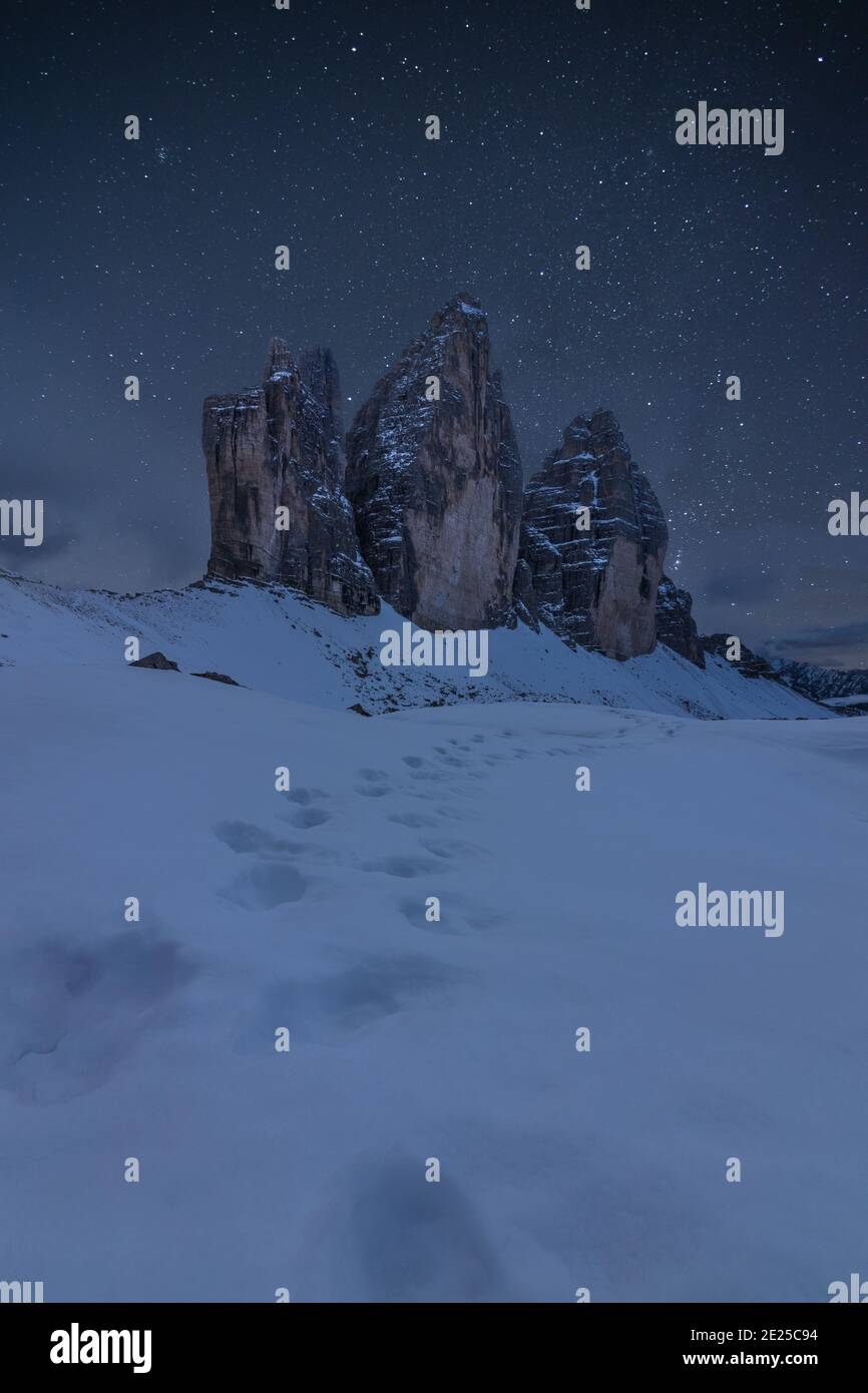 Une photo de quelques pas dans la neige en face de Tre Cime di Lavaredo, site classé au patrimoine de l'UNESCO dans les Dolomites italiens, lors d'une nuit étoilée Banque D'Images