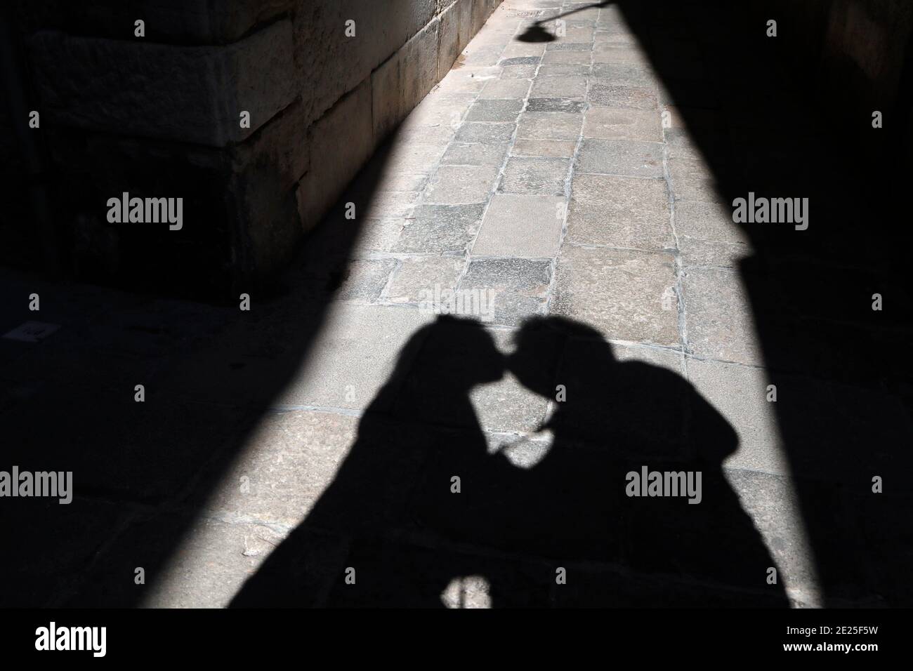 Ombre d'un jeune couple embrassant dans la rue. Banque D'Images