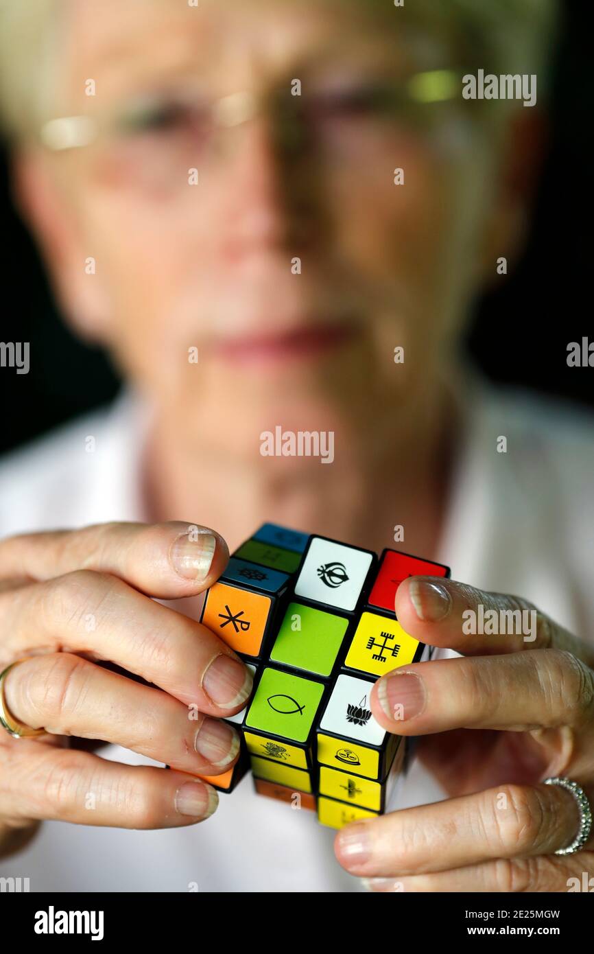 Femme avec un cube de Rubik avec des symboles religieux. Concept de dialogue interreligieux et interreligieux. France. Banque D'Images