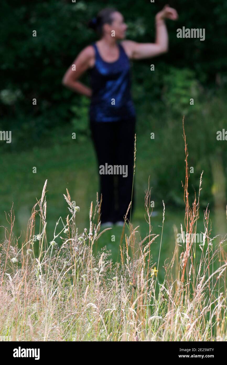 Femme pratiquant l'exercice Qi Gong ou Tai Chi dans la nature. France. Banque D'Images