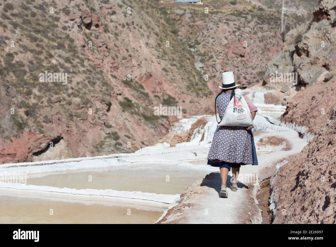 Salines à Salinas.Un ouvrier porte du sel le long des terrasses. Banque D'Images