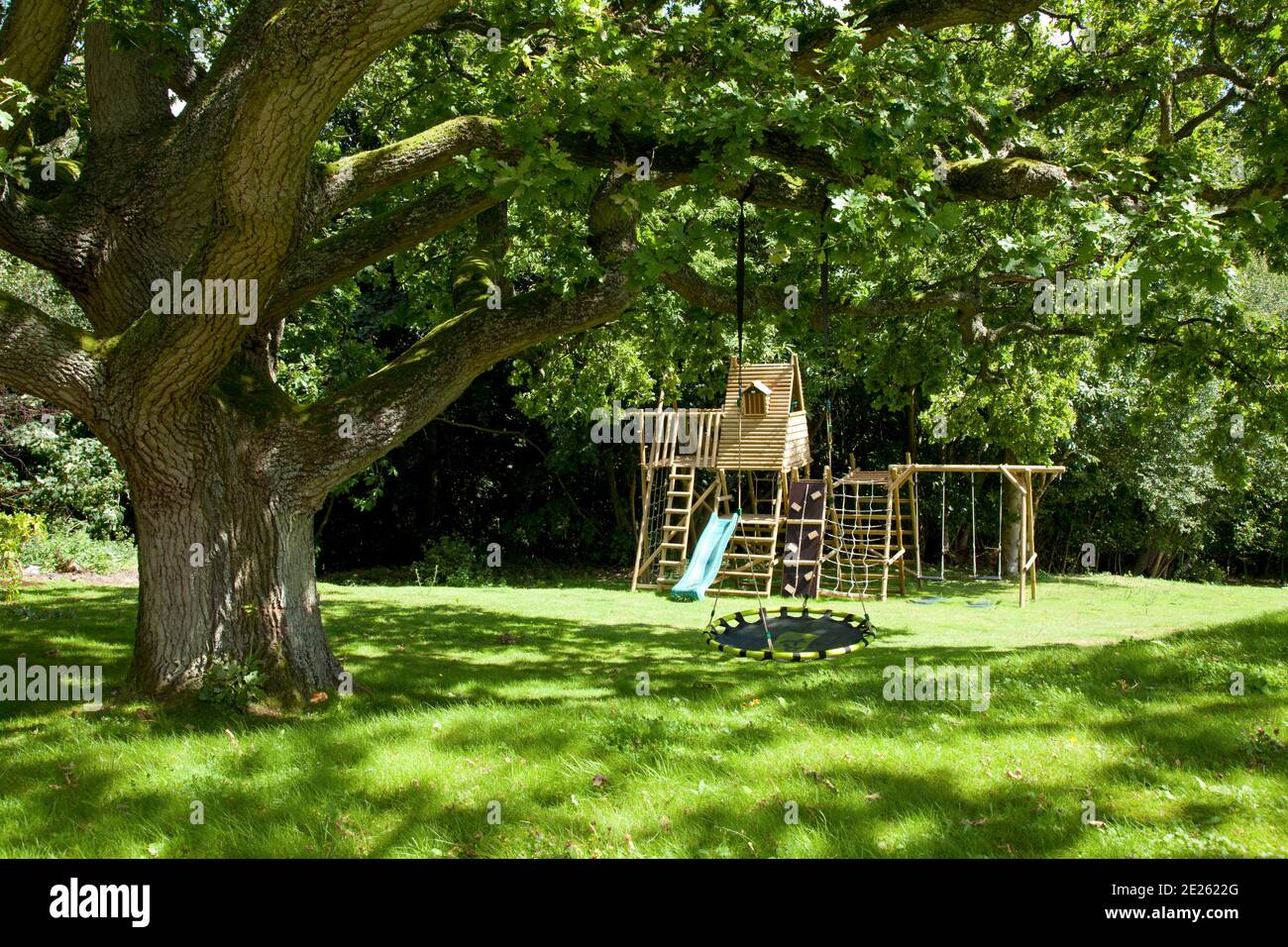 Aire de jeux avec cadre d'escalade et balançoire en privé boisé jardin Banque D'Images