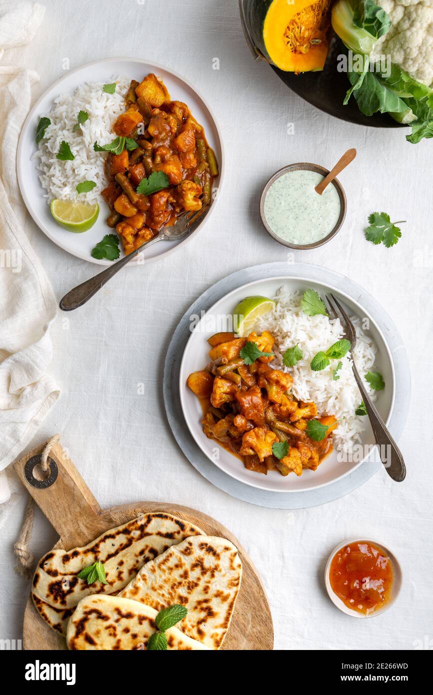 Vue de dessus d'un curry Balti végétarien, végétarien indien avec chou-fleur et citrouille servi avec raita, pain naan et chutney de mangue et riz basmati Banque D'Images