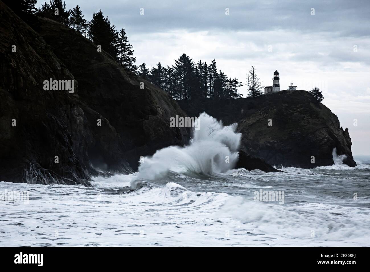 WA19105-00...WASHINGTON - des vagues se déferlent dans les falaises de la rivière Columbia Sortie sous le phare de Cape déception dans l'État P de Cape déception Banque D'Images