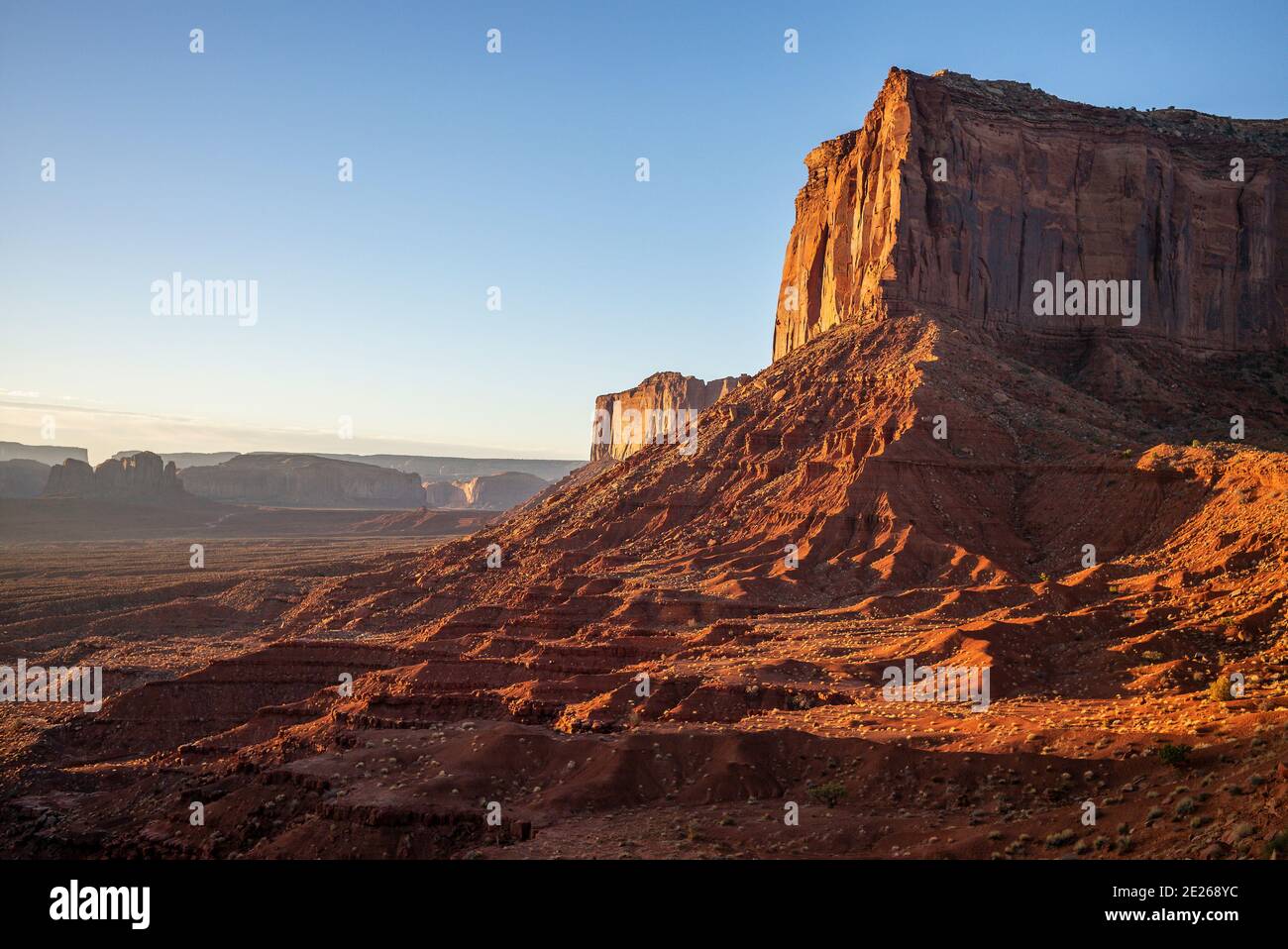 Le lever du soleil s'incline à travers la formation rocheuse de Mitchell Mesa dans le parc tribal de Monument Valley Navajo, en Arizona et dans l'Utah, aux États-Unis Banque D'Images