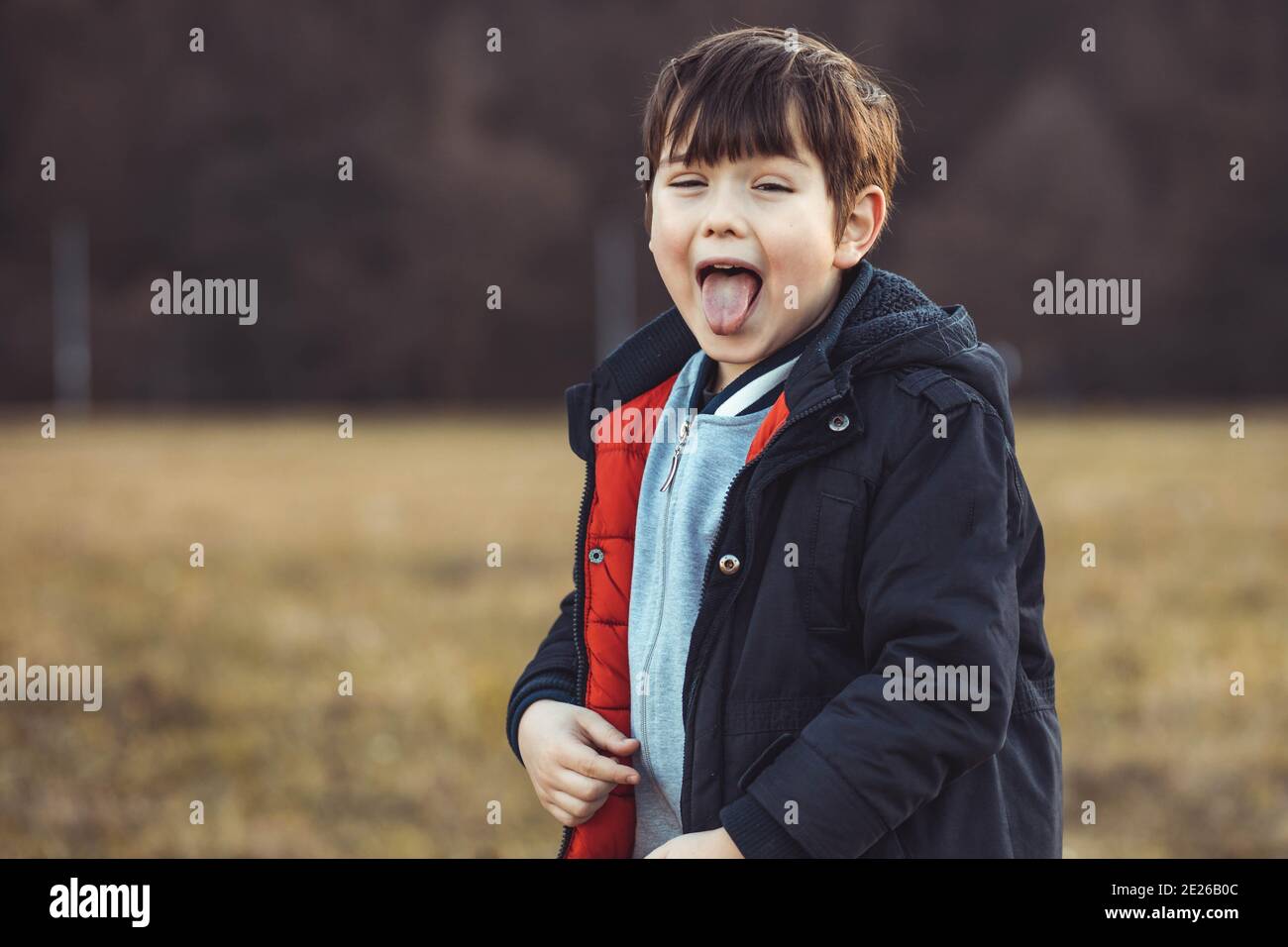 Portrait d'un mignon petit garçon qui colle de sa langue Banque D'Images