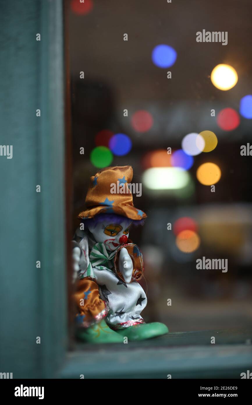 mécontent clown jouet gros plan. arrière-plan bokeh. devant la fenêtre clown jouet triste Banque D'Images
